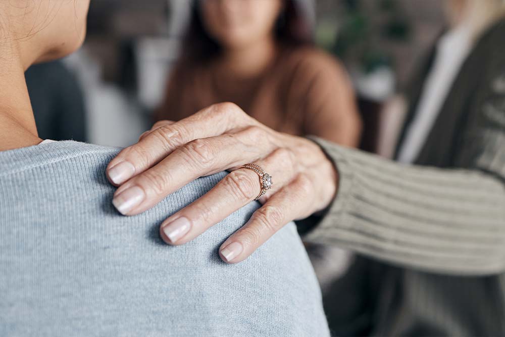 hand and older woman supports daughter